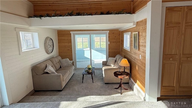 living area featuring light carpet and wood walls