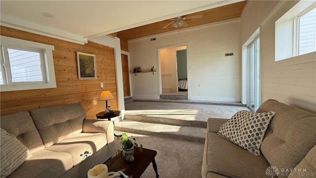 carpeted living room featuring wood walls