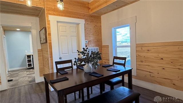 dining area featuring wood walls and wood finished floors