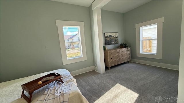 bedroom with dark carpet and baseboards