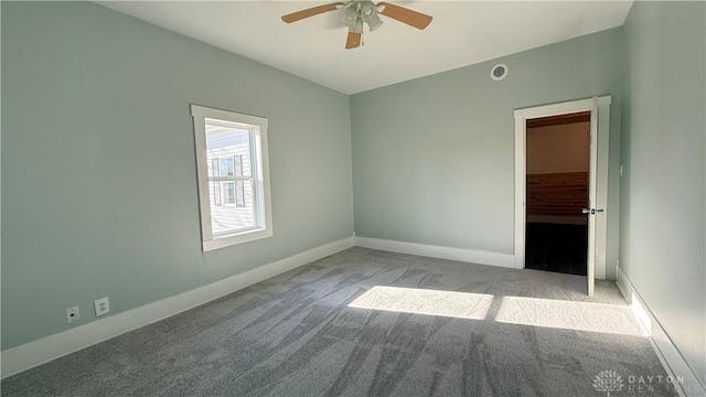 carpeted spare room with baseboards and a ceiling fan