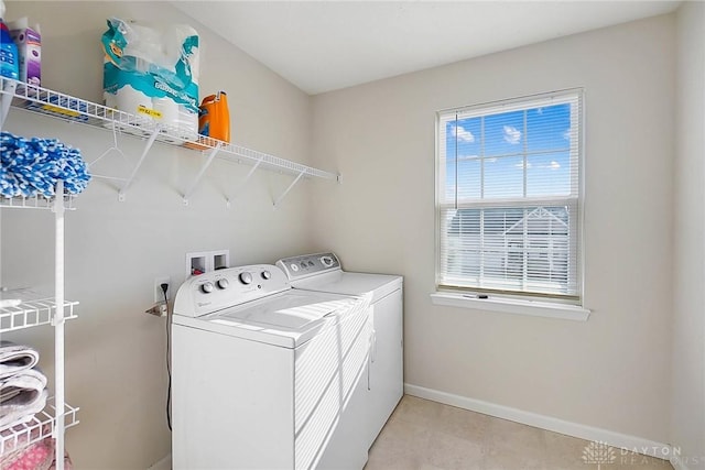 laundry area with baseboards, laundry area, and washer and dryer