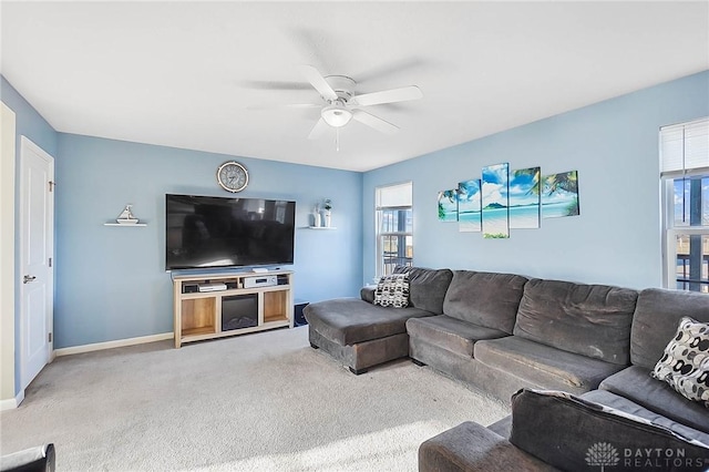 carpeted living room with a ceiling fan and baseboards