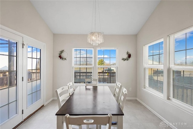 dining area featuring baseboards, vaulted ceiling, and a notable chandelier