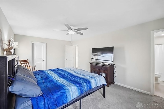 bedroom with ensuite bathroom, carpet flooring, a ceiling fan, and baseboards