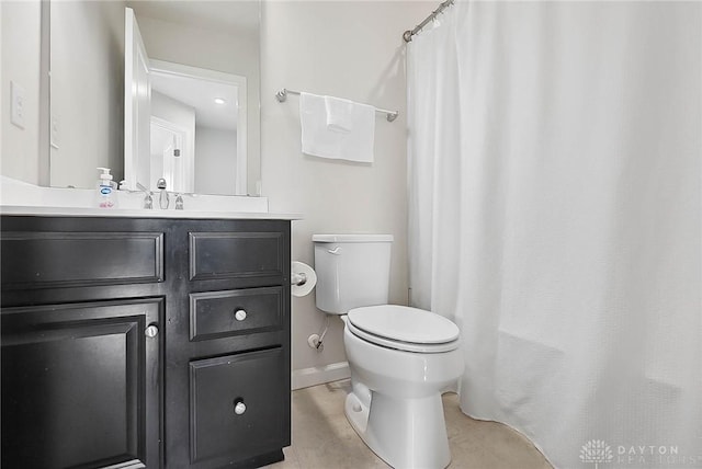 bathroom featuring curtained shower, tile patterned flooring, toilet, vanity, and baseboards