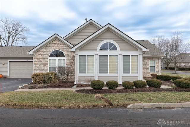 view of front of home featuring a garage, driveway, and a shingled roof