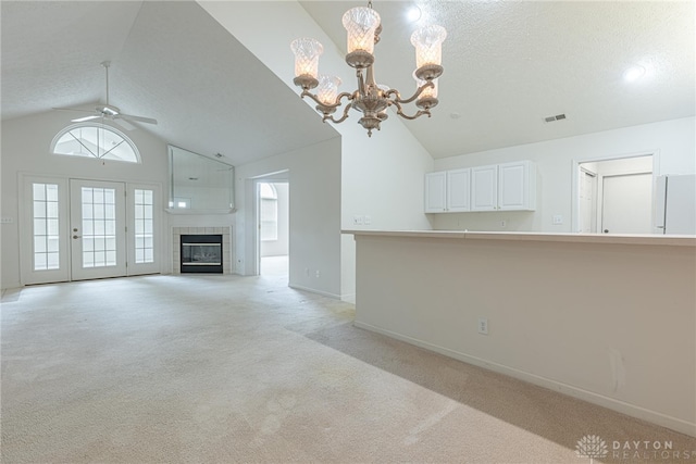 unfurnished living room featuring light carpet, baseboards, visible vents, a textured ceiling, and ceiling fan with notable chandelier