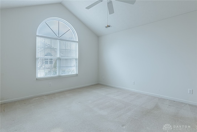 carpeted spare room with lofted ceiling, baseboards, and a ceiling fan