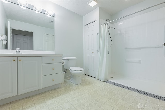 full bath with a textured ceiling, a shower with shower curtain, vanity, and toilet