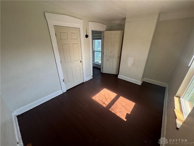 unfurnished bedroom with visible vents, baseboards, and wood finished floors