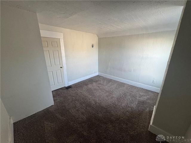 unfurnished room featuring baseboards, a textured ceiling, visible vents, and carpet flooring