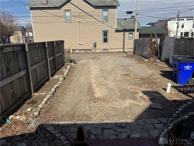 view of yard with a patio area, fence, and driveway