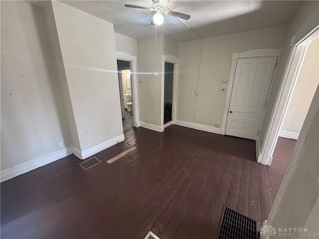 spare room with baseboards, ceiling fan, visible vents, and hardwood / wood-style floors