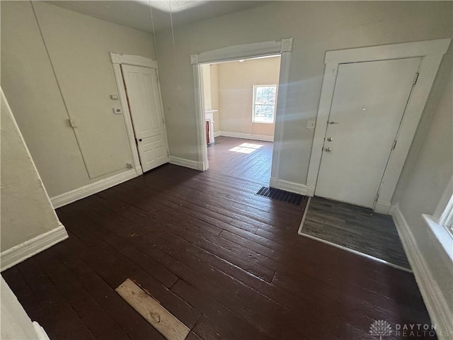 foyer entrance featuring baseboards and dark wood finished floors