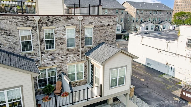 back of property featuring a residential view and brick siding