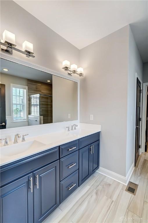 121 Lowe Ln, Dayton, OH 45402 - bathroom featuring double vanity, visible vents, baseboards, and a sink