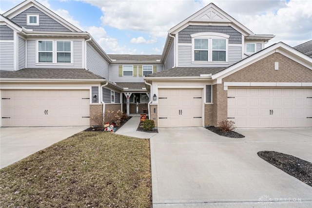 view of front facade with an attached garage, concrete driveway, and brick siding