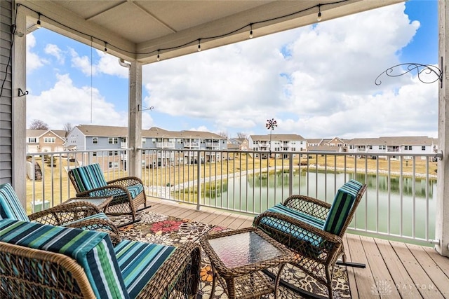 balcony featuring a residential view and a water view