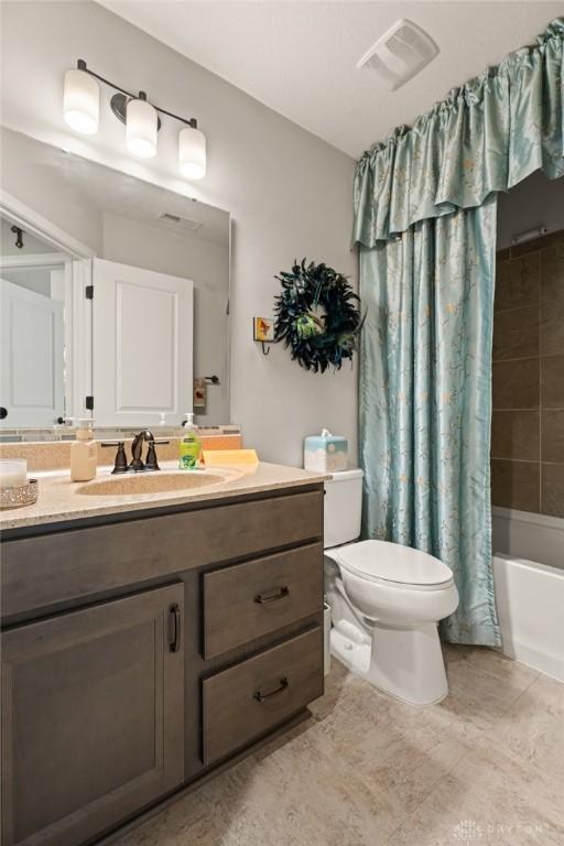 full bath with visible vents, toilet, tile patterned floors, shower / bath combination with curtain, and vanity