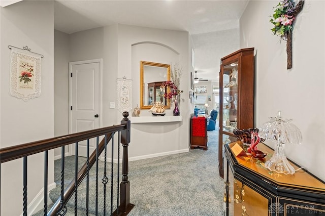 corridor with carpet flooring, an upstairs landing, and baseboards