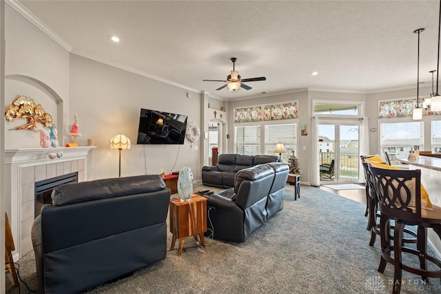 carpeted living room featuring a fireplace, a ceiling fan, crown molding, and recessed lighting