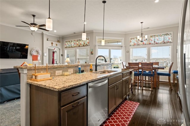 kitchen featuring dishwasher, dark wood-type flooring, a sink, and crown molding