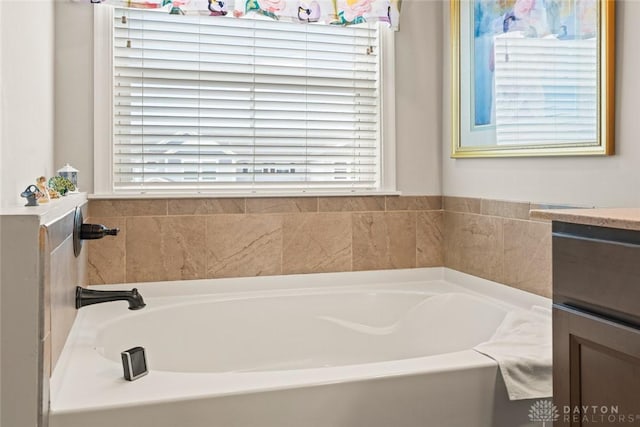 full bath featuring a garden tub and vanity