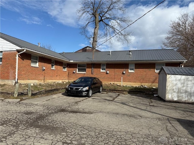 view of parking / parking lot featuring a storage shed