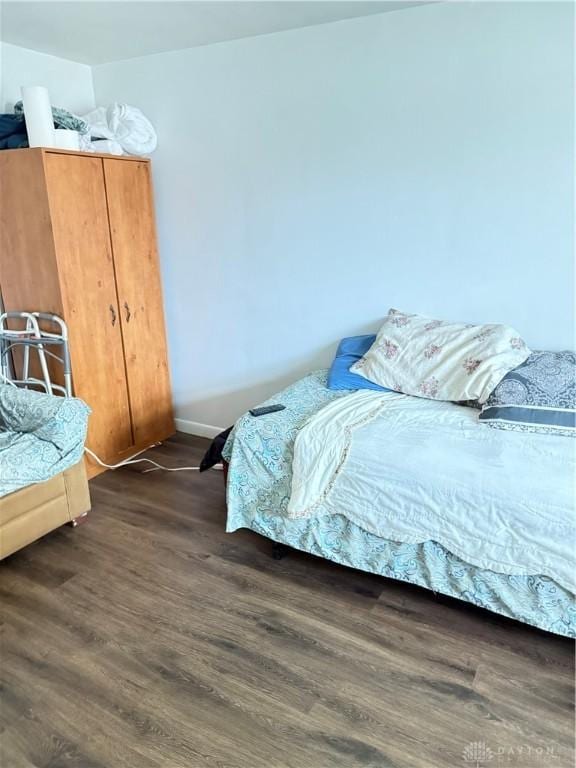 bedroom featuring dark wood-style floors and baseboards