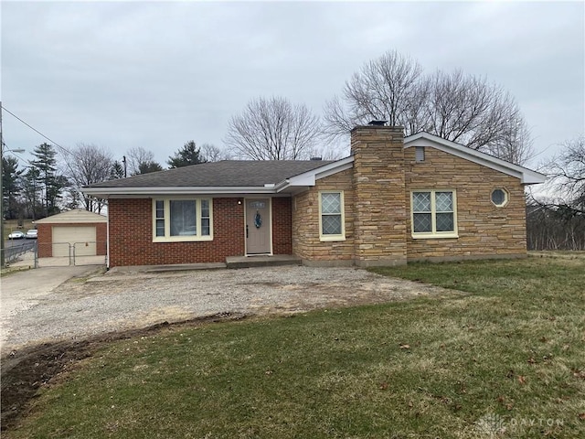 single story home with an outbuilding, brick siding, a chimney, a front yard, and driveway