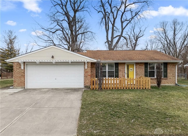 ranch-style home featuring a front yard, concrete driveway, brick siding, and an attached garage