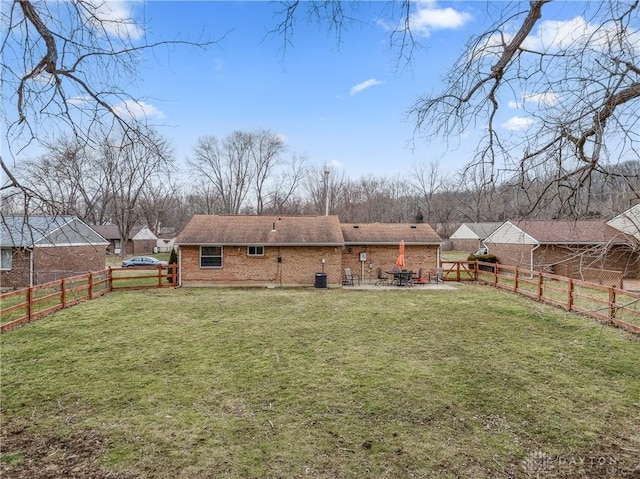 back of property with a yard, a fenced backyard, a patio area, and brick siding