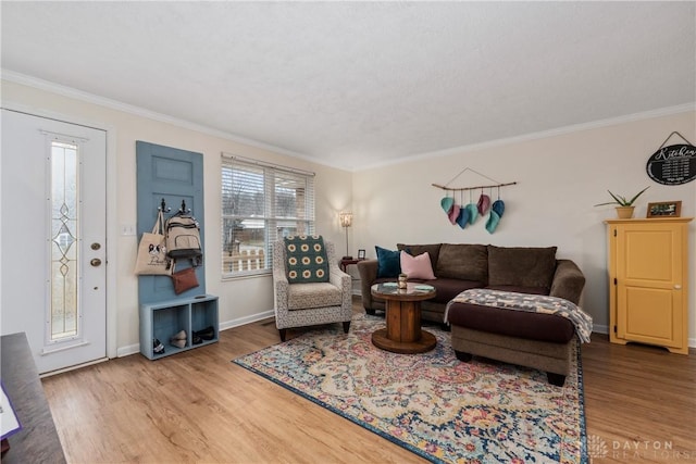 living area with crown molding, baseboards, and wood finished floors