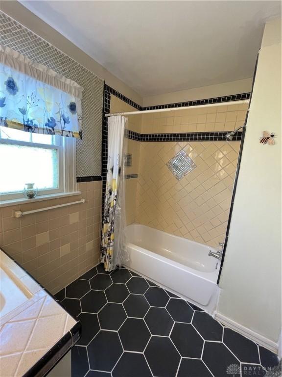 50 Woodcrest Ave, Dayton, OH 45405 - full bathroom with tile patterned floors, shower / tub combo, vanity, and tile walls