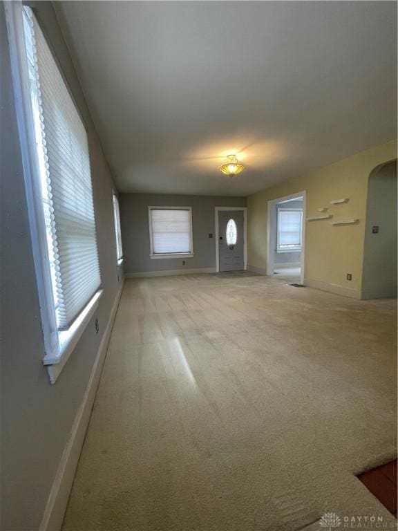 50 Woodcrest Ave, Dayton, OH 45405 - unfurnished living room featuring arched walkways, baseboards, and light colored carpet