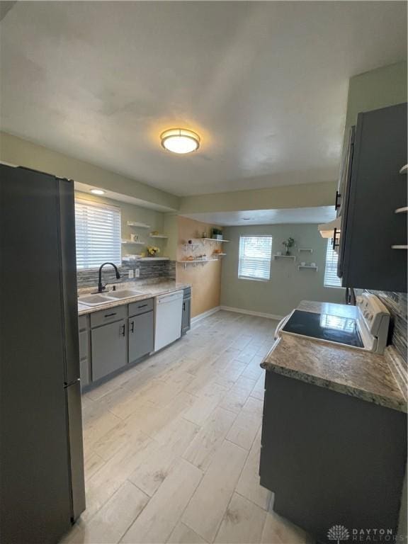 50 Woodcrest Ave, Dayton, OH 45405 - kitchen with a sink, open shelves, freestanding refrigerator, dishwasher, and baseboards
