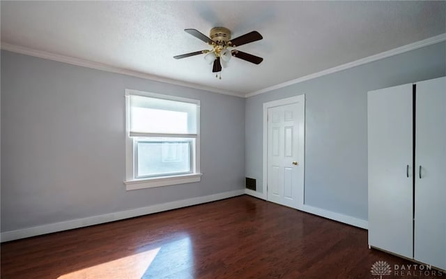 empty room with crown molding, ceiling fan, wood finished floors, and baseboards