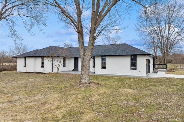 back of property with a patio area, a shingled roof, and a yard