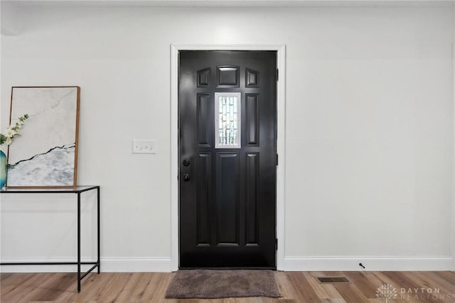 entrance foyer featuring baseboards and wood finished floors