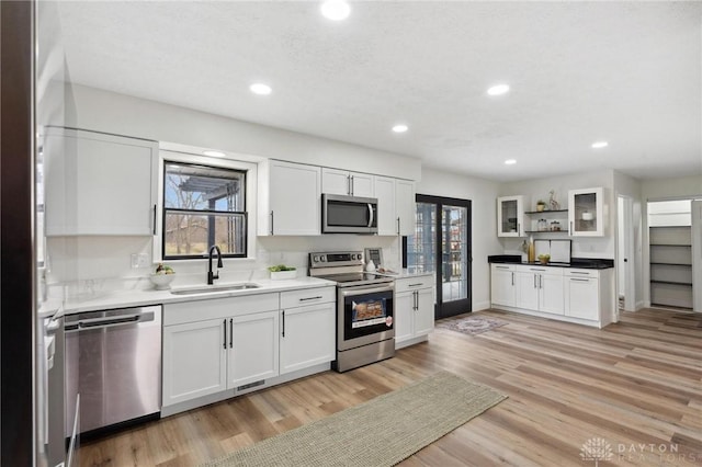 kitchen with stainless steel appliances, plenty of natural light, a sink, and white cabinets