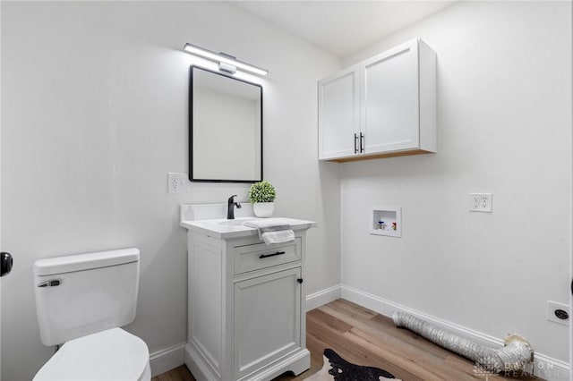 bathroom with vanity, wood finished floors, toilet, and baseboards