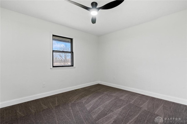 unfurnished room featuring ceiling fan, dark carpet, visible vents, and baseboards