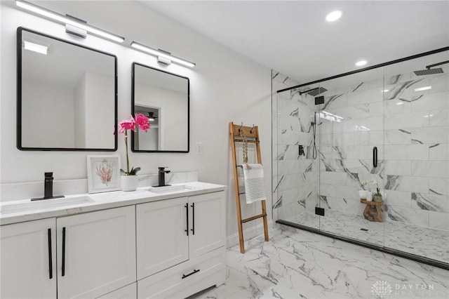 full bathroom featuring double vanity, marble finish floor, a marble finish shower, and a sink