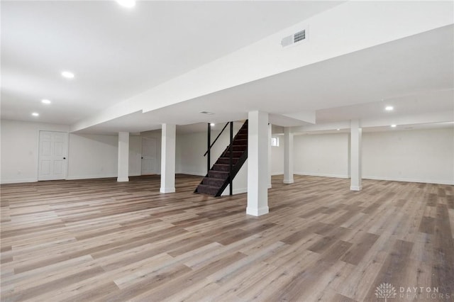 finished basement with recessed lighting, visible vents, baseboards, stairway, and light wood finished floors