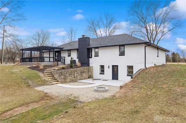 back of house featuring a patio area, a chimney, a pergola, and a yard