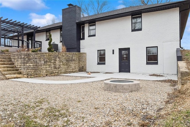 back of property with stairs, brick siding, a chimney, and a pergola