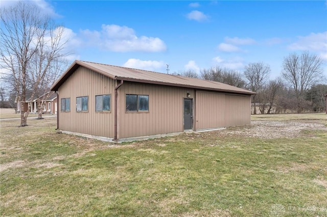 view of property exterior with metal roof and a yard