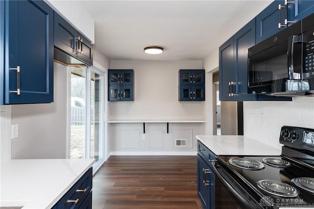 kitchen with dark wood finished floors, blue cabinets, light countertops, black appliances, and backsplash