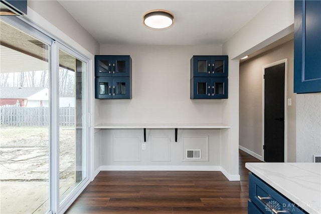 dining room featuring dark wood-style flooring, visible vents, and baseboards